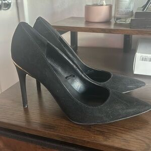 Suede black pumps with a gold color accent on the back . In very good condition.